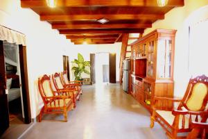 a living room with chairs and a wooden cabinet at Kandy House Hiriketiya in Dickwella