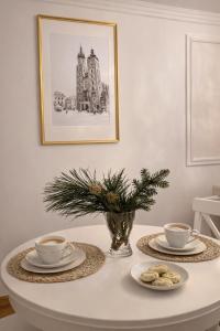 un tavolo con due tazze di caffè e biscotti sopra di ApAzory Kraków - przytulny apartament na wyłączność a Cracovia