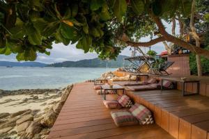 un ponte di legno con cuscini sulla spiaggia di DECHO BEACH RESORT a Koh Lipe