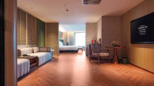 un salon avec un canapé et une télévision dans l'établissement Hotel Indigo Harbin Central Avenue by IHG, à Harbin