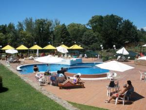 un grupo de personas sentadas alrededor de una piscina en Gran Hotel del Lago en La Falda