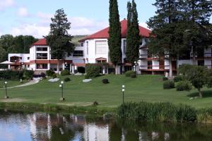 un hotel con un campo de golf junto a un lago en Gran Hotel del Lago en La Falda