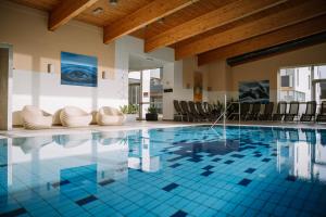 a swimming pool with blue tiles in a building at Hotel Auszeit St Lambrecht in Sankt Lambrecht