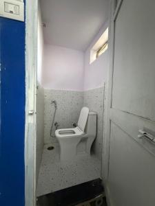 a bathroom with a toilet in a small room at Brij niwas in Udaipur
