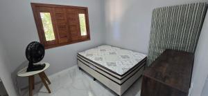 a small bedroom with a small bed and a window at Casa Temporada Conchinha do Mar in São Mateus +18 photos