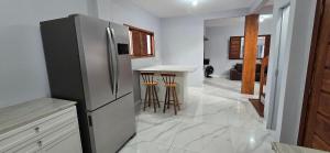 a kitchen with a stainless steel refrigerator and a counter at Casa Temporada Conchinha do Mar in São Mateus