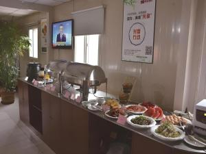 a buffet with plates of food on a counter at Shell Baoding Dongfeng Middle Road Kailian Hotel in Baoding