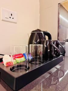 a kitchen counter with three cups and a tea kettle at StayWorks studios in Greater Noida +9 photos