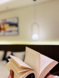 a person holding two books in their hand at StayWorks studios in Greater Noida