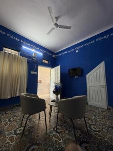 a room with two chairs and a blue wall at Brij niwas in Udaipur +8 photos