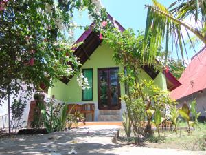 een groen huis met een rood dak bij Brother Bungalow in Gili Trawangan