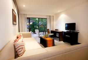un soggiorno con un divano e una televisione di Woraburi Phuket Resort & Spa - SHA Plus a Karon Beach