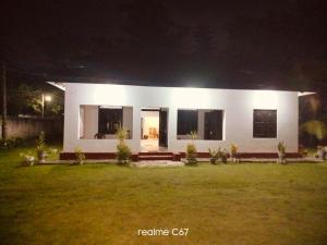 een wit huis met een gazon ervoor 's nachts bij Villa77 Benthota in Bentota