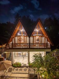 een huis met een balkon aan het strand 's nachts bij The Pyramid Ubud River Villas in Gianyar