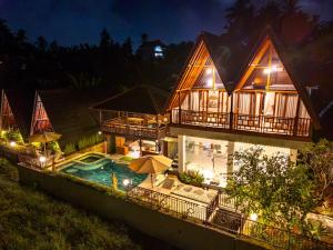 an aerial view of a house with a swimming pool at night at The Pyramid Ubud River Villas in Gianyar