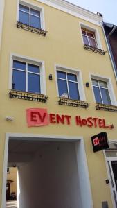 ein gelbes Gebäude mit einem Schild, auf dem das Ereignis angezeigt wird in der Unterkunft Event Hostel - Opole in Oppeln