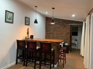 a kitchen with a bar with a brick wall at Armadale Cottage in Lidgetton +1 photo