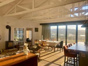 a living room with a table and a large window at Armadale Cottage in Lidgetton