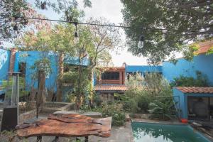 a garden with a wooden bench in front of a blue building at Casa Palomar in Guanajuato +84 photos