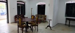 een eetkamer met een tafel en stoelen en een piano bij Villa77 Benthota in Bentota +11 foto's