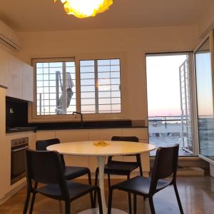 a kitchen with a table and chairs and windows at Ocean View House in Nettuno