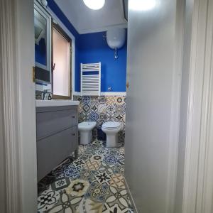 a blue bathroom with a toilet and a sink at Ocean View House in Nettuno +21 photos