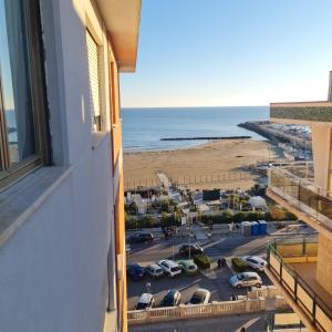 a view of the beach from a balcony of a building at Ocean View House in Nettuno
