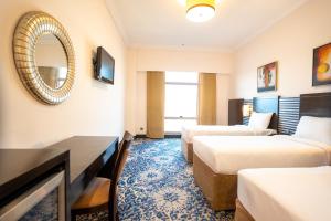 ein Hotelzimmer mit zwei Betten und einem Spiegel in der Unterkunft Al Hidayah Towers Hotel in Mekka + 12 Fotos