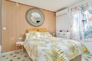 una camera da letto con un letto e uno specchio sul muro di Casa El Camaleón ad Almuñécar