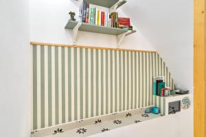 una scala con una parete a strisce verdi e bianche di Casa El Camaleón ad Almuñécar
