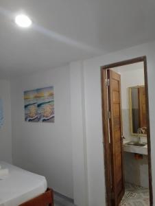 a room with a bathroom with a sink and a mirror at Kenji Guest House in San Vicente