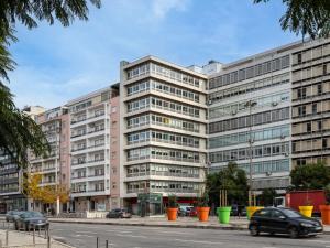 ein großes Gebäude an einer Stadtstraße mit Autos in der Unterkunft Lisbon Serviced Apartments - Alvalade in Lissabon