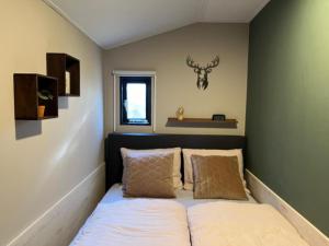 een bed in een kamer met 2 kussens bij Veluwepark de Bosgraaf in Apeldoorn