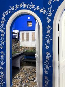 a bathroom with a blue wall with white flowers at Brij niwas in Udaipur