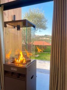 un barbecue avec un feu allumé devant une fenêtre dans l'établissement Mit Warde Cabin, à Batroun