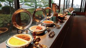a row of sinks with bowls of food and mirrors at Koriyama View Hotel Annex in Koriyama