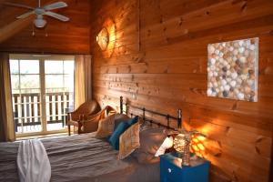 a bedroom with a bed and a wooden wall at Trésor en Bois Chambres d'Hôtes in Autoire