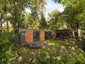 een klein huisje in een tuin met een prieel bij Veluwepark de Bosgraaf in Apeldoorn
