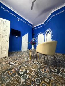 a blue room with a chair and blue walls at Brij niwas in Udaipur