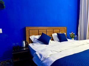 a blue bedroom with a bed with blue walls at Brij niwas in Udaipur