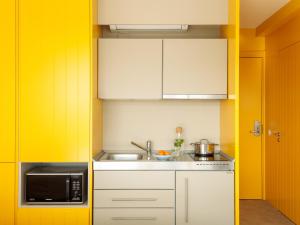 eine Küche mit Spüle und Mikrowelle in der Unterkunft Lisbon Serviced Apartments - Alvalade in Lissabon