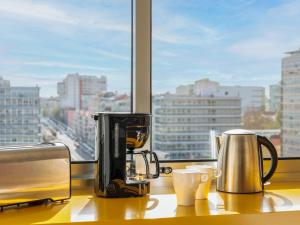 eine Theke mit Kaffeemaschine und zwei Tassen darauf in der Unterkunft Lisbon Serviced Apartments - Alvalade in Lissabon