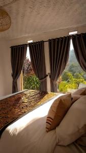 a bedroom with a large bed with black curtains at Little Munduk Villa A Private Mountain Escape in Munduk