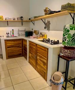 a kitchen with wooden cabinets and a stove at Little Munduk, full private villa in Munduk