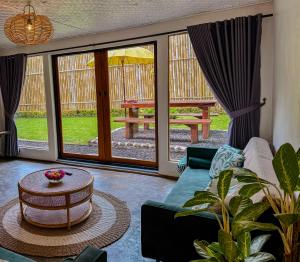 a living room with a couch and a table at Little Munduk Villa A Private Mountain Escape in Munduk