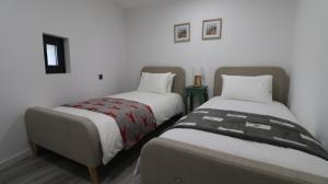 two beds sitting next to each other in a room at O Cantinho D'Alice in Sabugal