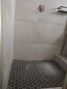 una doccia con pavimento piastrellato in bianco e nero di Cosy Three Bedroom Home a Livingstone
