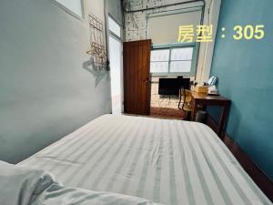 een slaapkamer met een bed, een bureau en een raam bij 阡陌-分享民宿 in Tainan +66 foto's