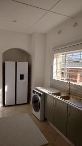una cucina con frigorifero e lavatrice di Cosy Three Bedroom Home a Livingstone