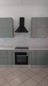 una cucina con armadi grigi e piano cottura. di Cosy Three Bedroom Home a Livingstone